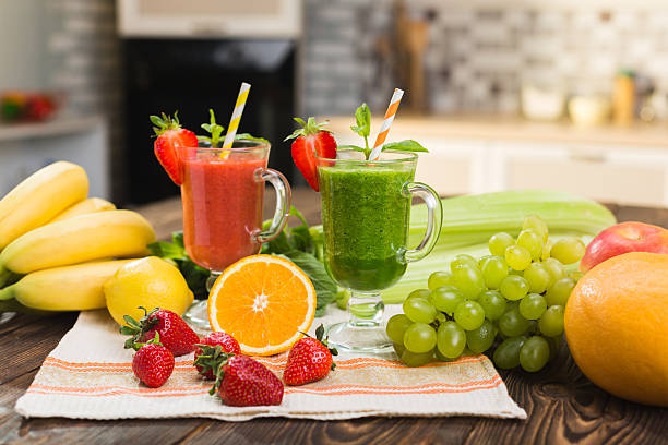 Fresh fruit and vegetable smoothie on kitchen table in glass